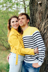 young couple in love in yellow clothes on nature against the background of a tree 1