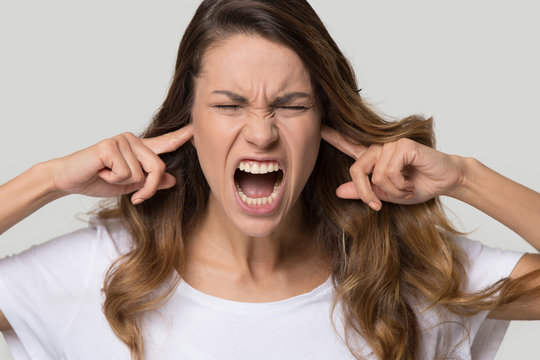 Close up portrait of screaming female close ears with fingers