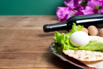 Passover celebration concept. bottle of wine, book, matzo, egg, cider and lettuce