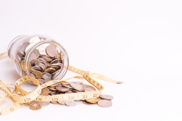 Coins in glass jar and measurement tape isolated on white background for copy space. Financial, economy and future planning concept.