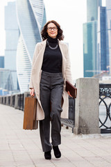 Beautiful middle-aged business woman with a small suitcase in hand