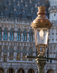 Fototapeta na wymiar Vintage street lamp with the Gothic Brussels Town Hall in the background on the famous Grand Place in Brussels, Belgium.