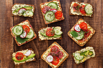 Sandwiches with cream cheese, vegetables and salami.