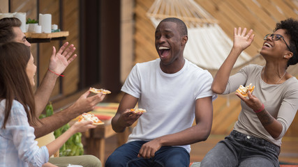 Happy diverse friends talking laughing sharing dinner in cafe