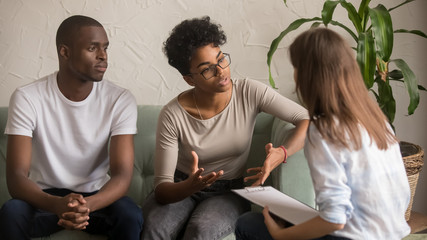 Unhappy african wife talking to psychologist complaining on bad relationship