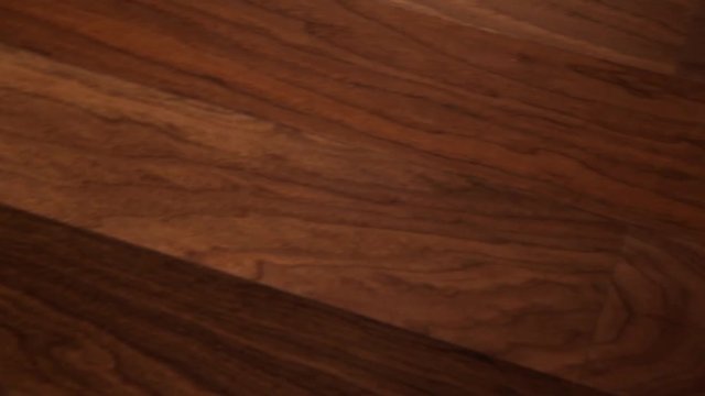 The camera moves along the floor, covered with laminated parquet with a brown wooden texture