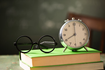 Back to school background with books and alarm clock