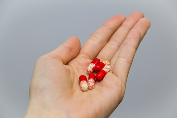 Tablets and pills on the palm of a person. An elderly man holds a lot of colored pills in old hands. Painful old age. Health care of older people. Top View