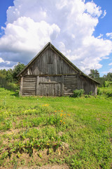 Summer landscape in the countryside in Latvia, East Europe. Old wooden shed