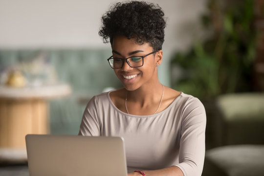 Happy african american woman using laptop work study in office