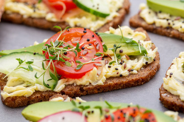 Sandwiches with cream cheese, vegetables and salami.