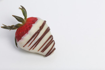 Strawberries glazed in black and white chocolate. Lie on a white background.
