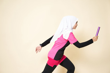 Sport Girl Wearing a Black/Pink Shirt and White Shawl is Running with a Baton