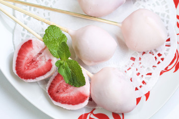 Strawberries in yogurt. Berries are dressed on wooden skewers and dipped in yogurt. Nearby are two...