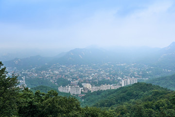 Fototapeta na wymiar A view of a city near Seoul surrounded by mountains seen from the North Sky Skyway.