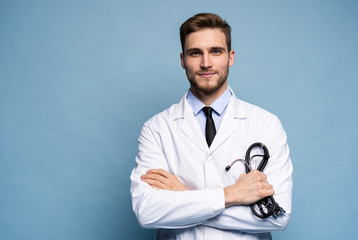 Portrait of confident young medical doctor on blue background.