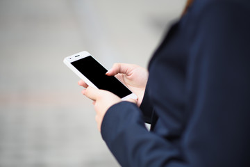 The business lady uses a smartphone on the street
