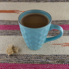 Turquoise Cup of coffee against the striped braided rug.