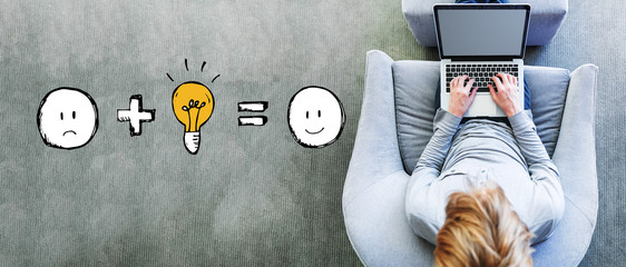 Good idea equals happy with man using a laptop in a modern gray chair