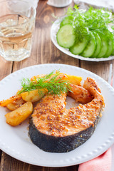 Salmon steak baked with mustard and potatoes, selective focus