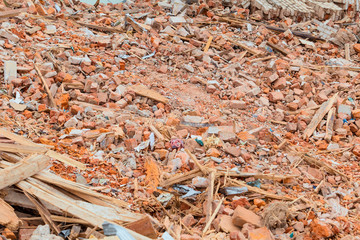 Construction debris from the dismantled building. Fragments of broken bricks, fragments of boards and cement masonry.