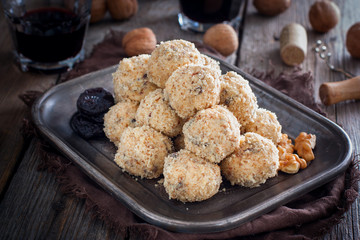Snack cheese balls with prunes and walnuts on a metal platter, horizontal