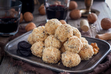 Snack cheese balls with prunes and walnuts on a metal platter, horizontal