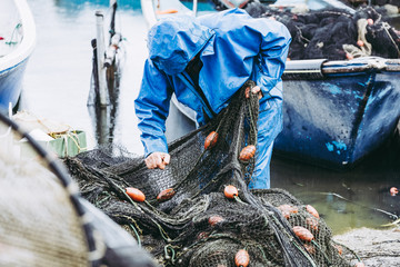 Pêcheur en train de ranger ses filets