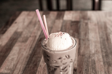 iced chocolate and vanilla ice cream with ball jelly orange, on old wood table