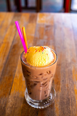 iced chocolate and vanilla ice cream with ball jelly orange, on old wood table