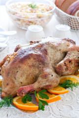 Duck baked with oranges on a white table, selective focus