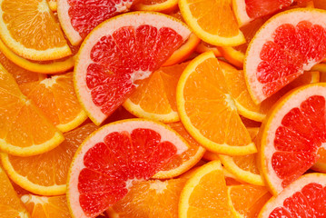 Slices of oranges and a grapefruits as a background.