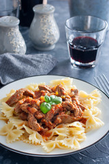 Beef in tomato sauce with farfalle, selective focus