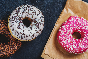 Sweet donuts on black stone table