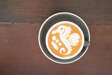 Coffee cup with latte art foam on wood table in coffee shop with copy space.Coffee is one of the most popular beverages.Improve Energy Levels and Burn Fat
