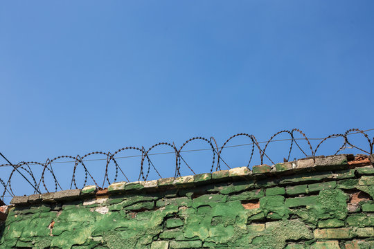 Concrete wall, against the backdrop of barbed wire, the concept of prison, salvation, Refugee, lonely, space for text