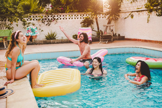 Happy Friends Having Fun In Swimming Pool  During Summer Vacation - Young People Relaxing And Floating On Air Lilo During In The Pool Resort - Friendship, Holidays And Youth Lifestyle Concept