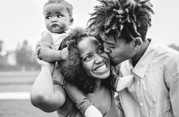 Happy African family having fun in a park outdoor - Mother and father with their daughter enjoying...