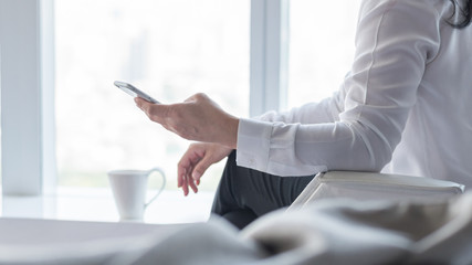 Business woman digital lifestyle using mobile smart phone working online via internet communication technology for emailing, banking money transfer from home in the morning