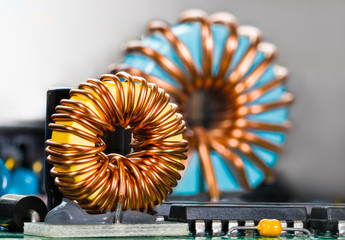 Inductors detail. Copper wire winding. Magnetic ferrite core. Inverter. Beautiful colored coils in...