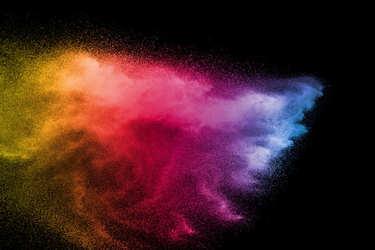Explosion of color powder on black background. Splash of color powder dust on dark background.