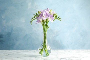 Bouquet of fresh freesia flowers in vase on table