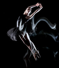 one caucasian young woman ballerina dancer dancing isolated on black background with  light painting motion blur speed effect