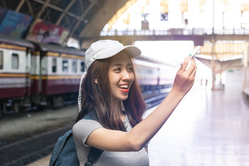 Attractive young Asian lady tourist with model airplane at train station. Travel lifestyle concept.