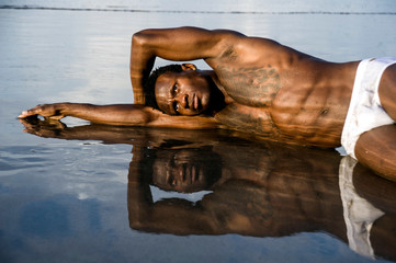 young attractive and sexy black afro American man with athletic muscular body posing cool in sea...