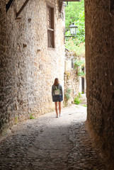 Fototapeta na wymiar Young woman walking between old houses