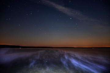 The fog creeps over the lake at night