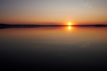 Fototapeta na wymiar Sunset on the lake without waves