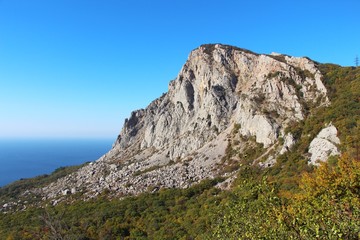 Fototapeta premium View of Foros Mountain above the autumn forest on the Crimean Peninsula. It's an unofficial name of the left part of Mshatka-Kaya mountain which indeed looks like an independent mountain.