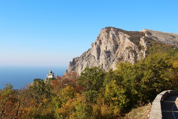 View of Foros Church, also known as The Church of Christ's Resurrection, and Foros Mount from road through the autumn forest. It's a popular tourist attraction on the outskirts of Yalta in the Crimea.